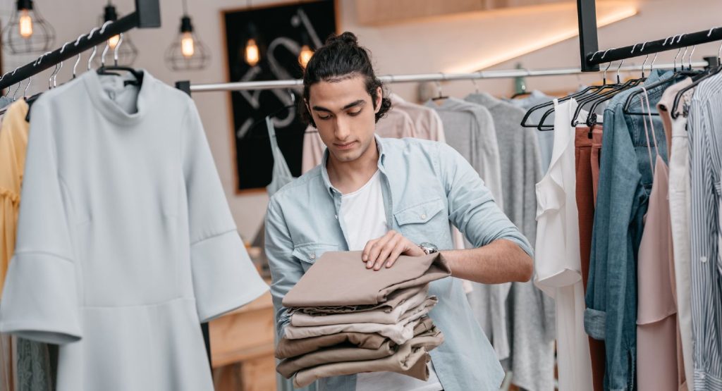 Butiksejer folder nyt tøj sammen i butik