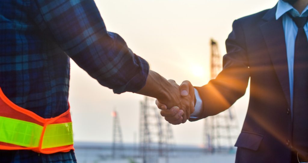 En bygherre og en forretningsmand deler et håndtryk ved en byggeplads